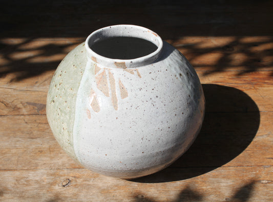 Wheel thrown and altered, this exquisite moon jar is made from Australian iron-rich, reclaimed stoneware and glazed in a combination of wood ash and traditional Japanese Shino glazes, allowing glimpses of the bare clay body beneath.